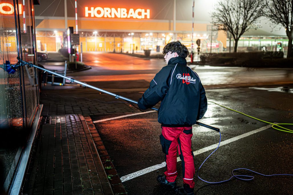 Glasreinigung in Essen: Ein Mitarbeiter von Rudolf Weber Gebäudedienste reinigt eine Glasfläche.